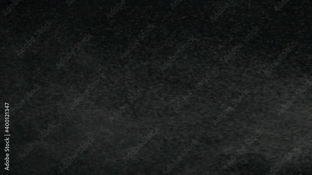 Vertical slow motion of powder, dust, snow particle floating on black background Vertical slow motion of powder, dust, snow particle floating on black background