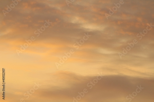 Sun below the horizon and clouds in the fiery dramatic orange sky at sunset or dawn backlit by the sun. Place for text and design