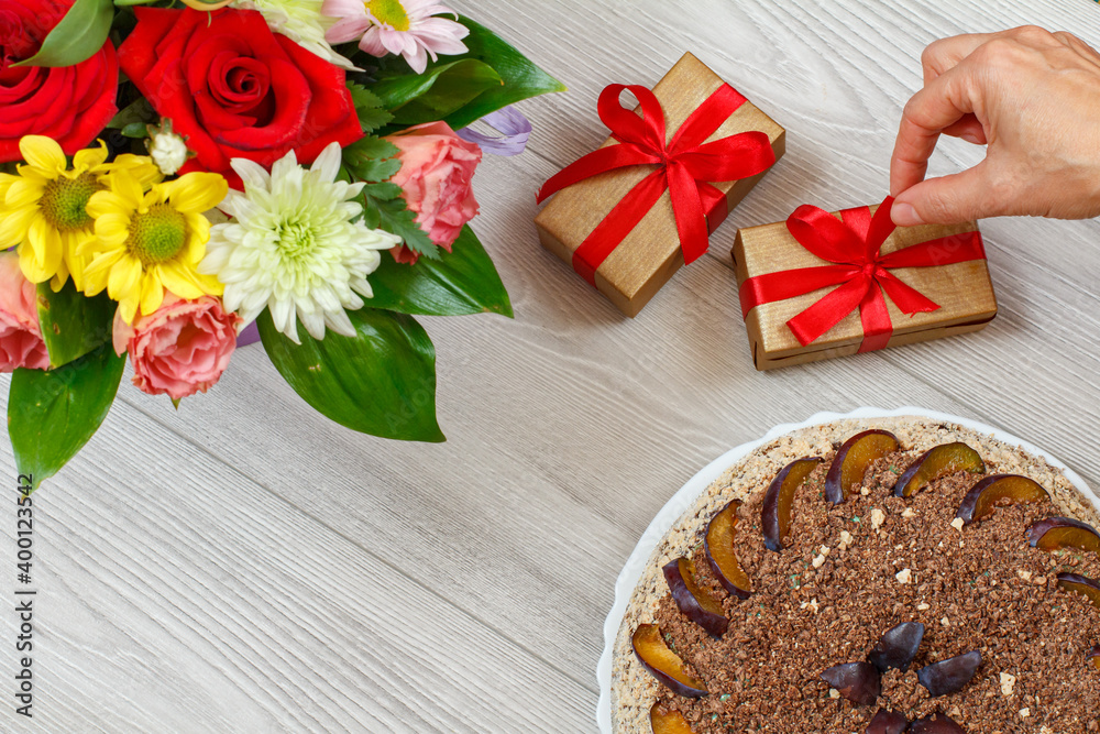 Chocolate cake decorated with plums and flowers