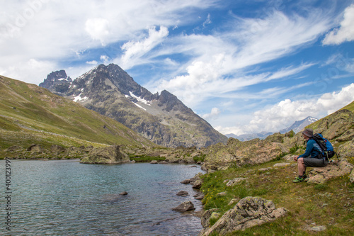 Man Sitting next to a High Alpine Lake in the Col d'Arsine in the Parc des Ecrins, Department Haute Alps, France