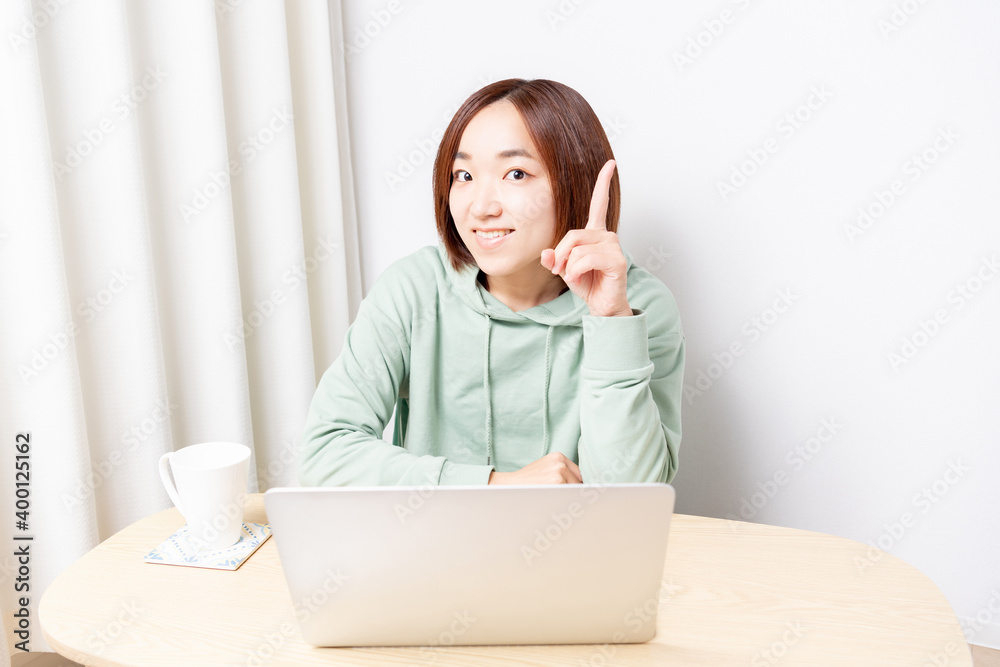 ノートパソコンを使いながらポイントを示す女性