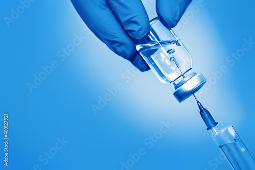 Vaccine in a bottle with a syringe on a blue background.The concept of medicine, healthcare and science.Coronavirus vaccine photo