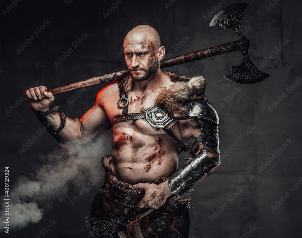 Fotka „Portrait of a furious viking warrior with grimy and bloody skin in  light armour in dark smokey background holding an axe on his shoulder“ ze  služby Stock | Adobe Stock