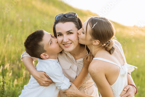 portrait of a happy family. a young mother with children. children kiss their mother on the cheeks