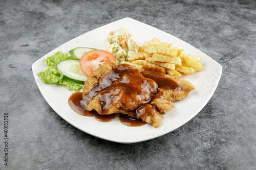 a plate of chicken chop set come with french fries and coleslaw