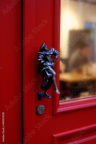 Vintage door handle in the form of a man on a red door