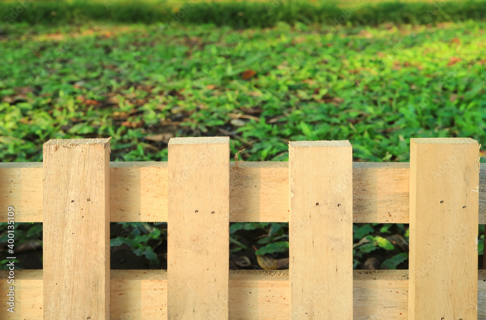 Rustic wooden fence with green grass lawn in background