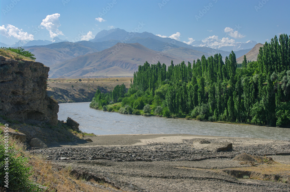 Scenic landscape view of Zeravshan river valley between Aini and Panjakent, with snow-capped Chimtarga in the distance, Sughd, Tajikistan