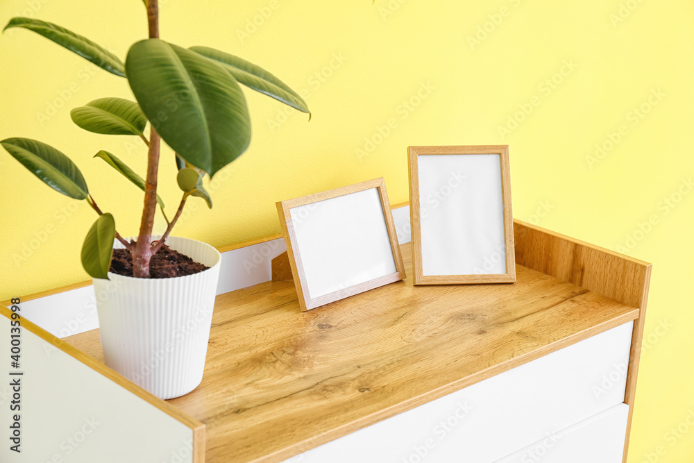 Fototapeta premium Chest of drawers near color wall in room