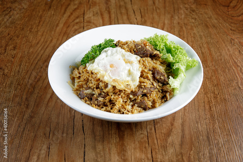 a plate of beef fried rice with fried egg on top