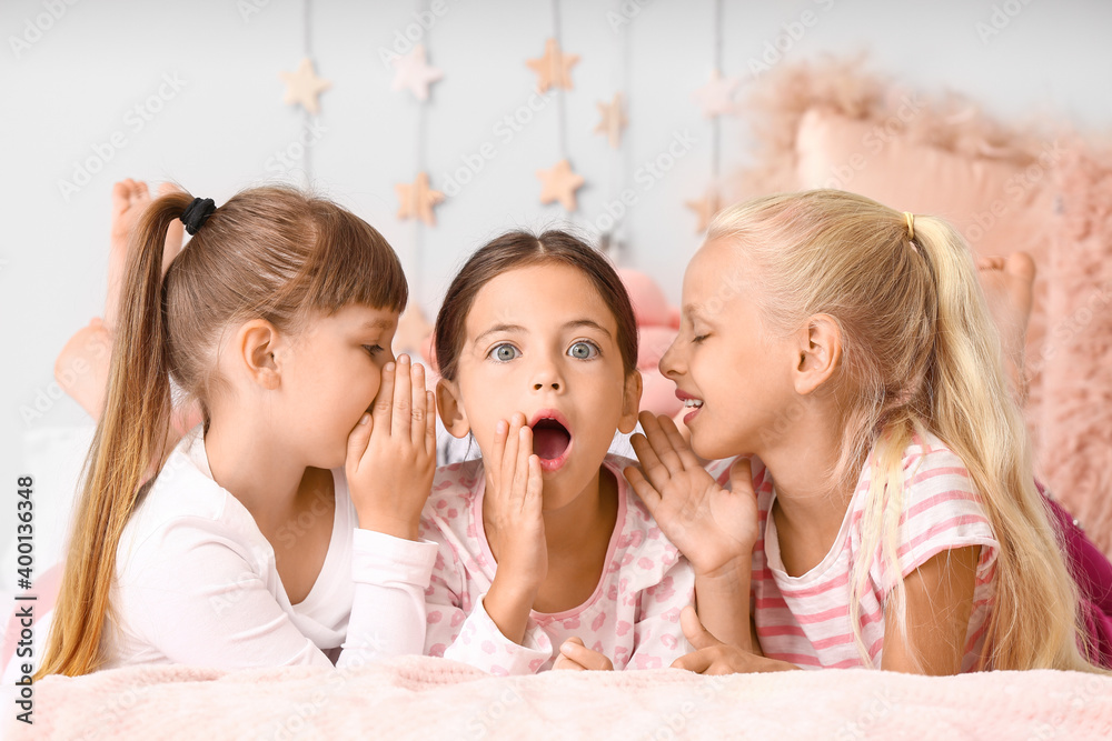 Cute little girls lying on bed in pajamas at home Stock Photo | Adobe Stock