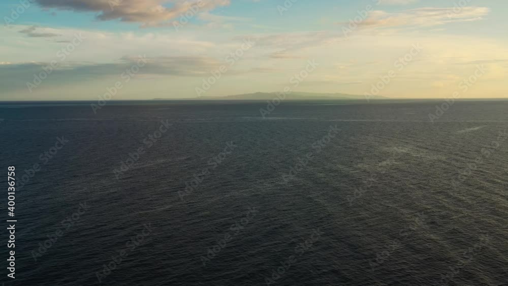 Seascape, aerial view. Flight over the sea at sunset. Blue sea and sky with clouds. Summer and travel vacation concept. Seascape, aerial view. Flight over the sea at sunset. Blue sea and sky with clouds. Summer and travel vacation concept.