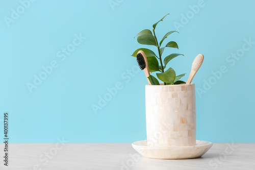 Holder with wooden toothbrushes on table