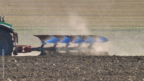 Canvas-taulu Farmer Ploughing Soil using Tractor with Mouldboard Plough on Sunny Day