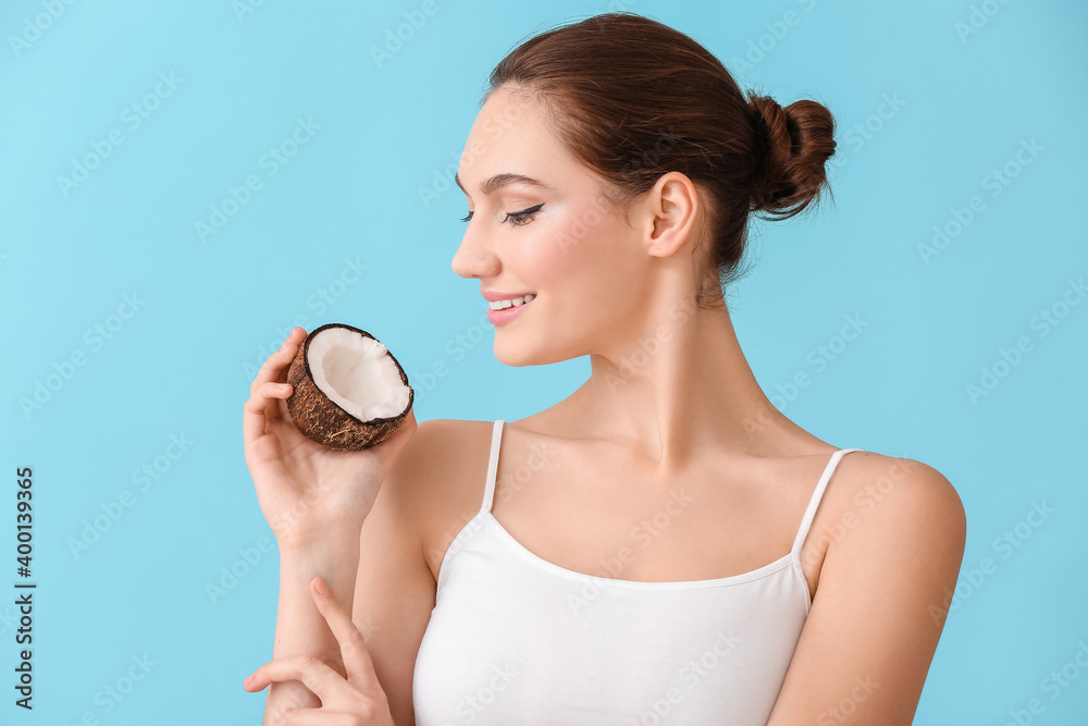 Beautiful young woman with coconut on color background Beautiful young woman with coconut on color background