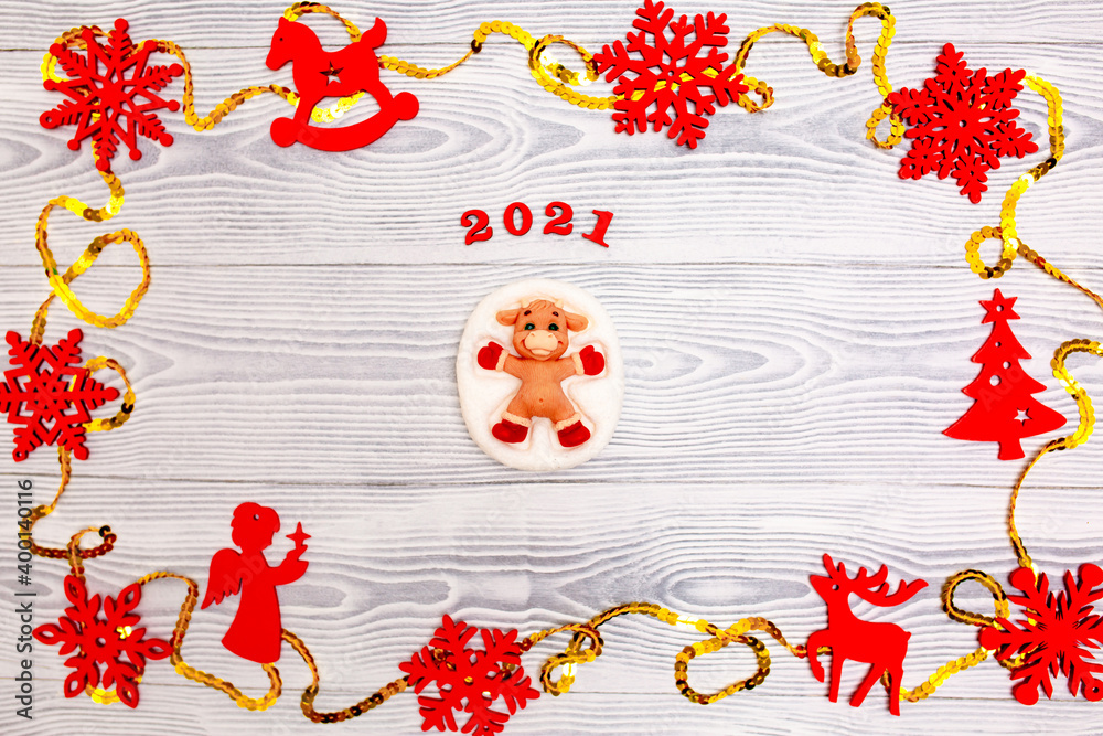 New Year 2021. Christmas greeting background. Holiday gifts and Christmas sales. The symbol of the year bull on a wooden background with elegant sparkling ornaments and snowflakes.