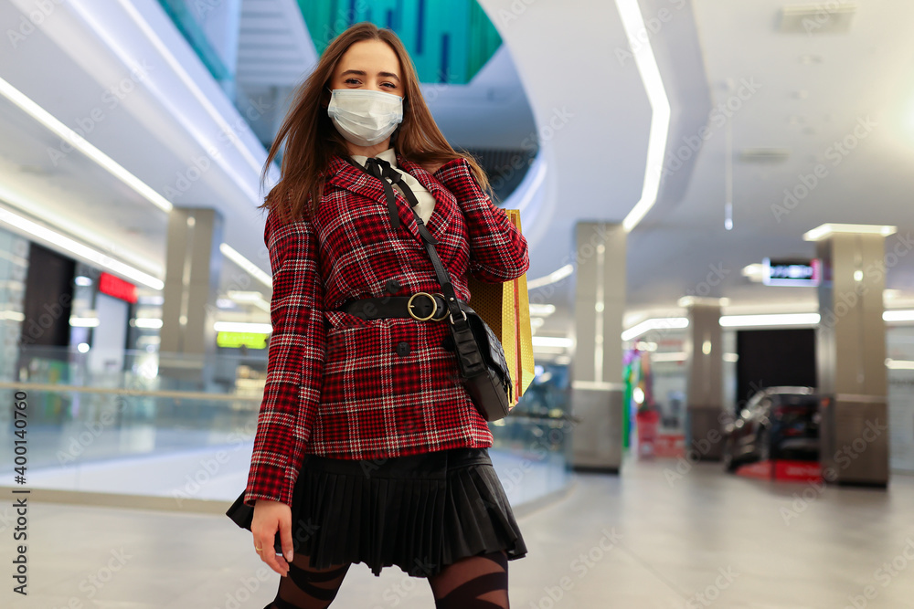 Fototapeta premium Young woman in protective mask with shopping bags