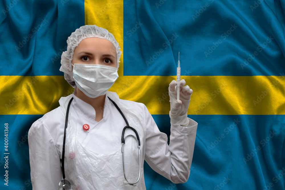 Young woman doctor in medical uniform on the background of the national flag of Sweden is holding a syringe. The concept of a new vaccine against the disease, flu vaccine vaccination. Young woman doctor in medical uniform on the background of the national flag of Sweden is holding a syringe. The concept of a new vaccine against the disease, flu vaccine vaccination.