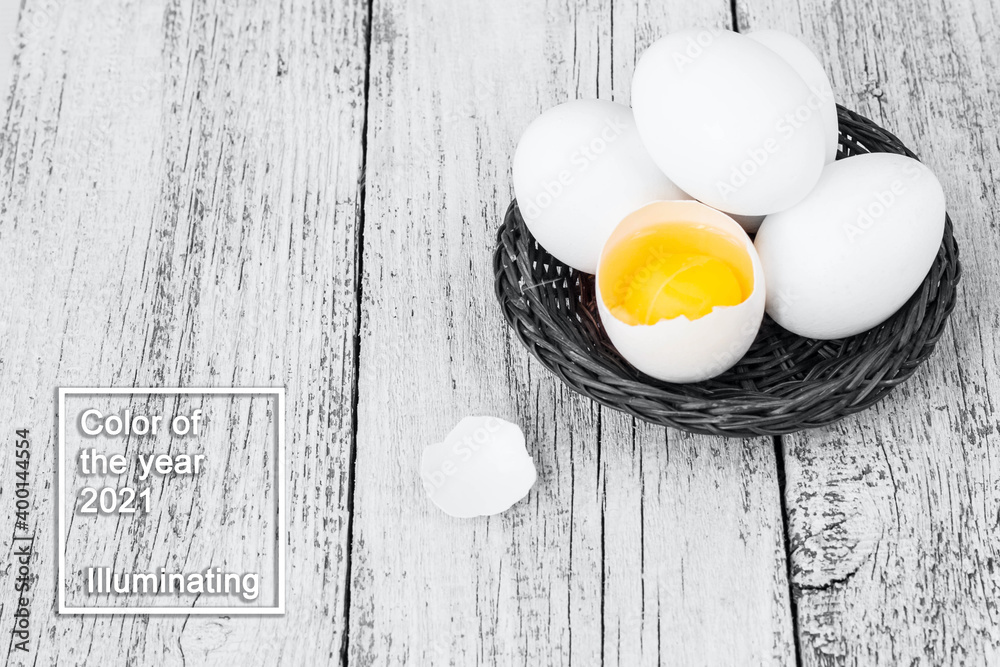 Broke One whole egg amongst white eggs in basket on a white background. Color of the year 2021 Broke One whole egg amongst white eggs in basket on a white background. Color of the year 2021