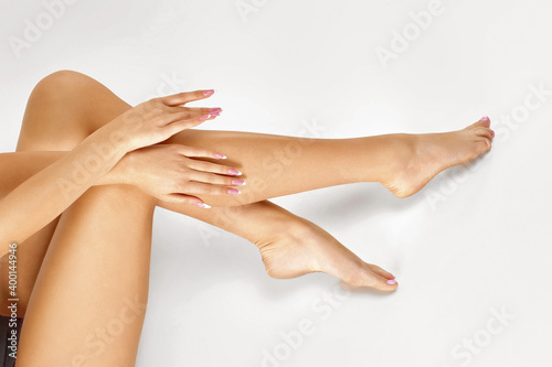 Perfect fit female legs on studio background. Woman touching her leg by hands. depilation, epilation and bodycare concept