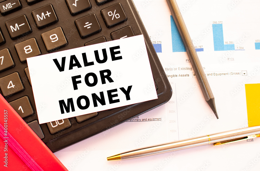 Text VALUE FOR MONEY on white card with metal pen, calculator and financial charts. Text VALUE FOR MONEY on white card with metal pen, calculator and financial charts.