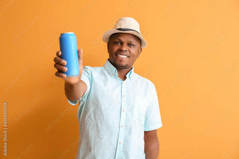 Handsome African-American man with soda on color background