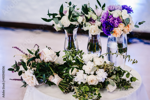 Composition of white, violet flowers and greenery on table. Close up. Wedding decor.