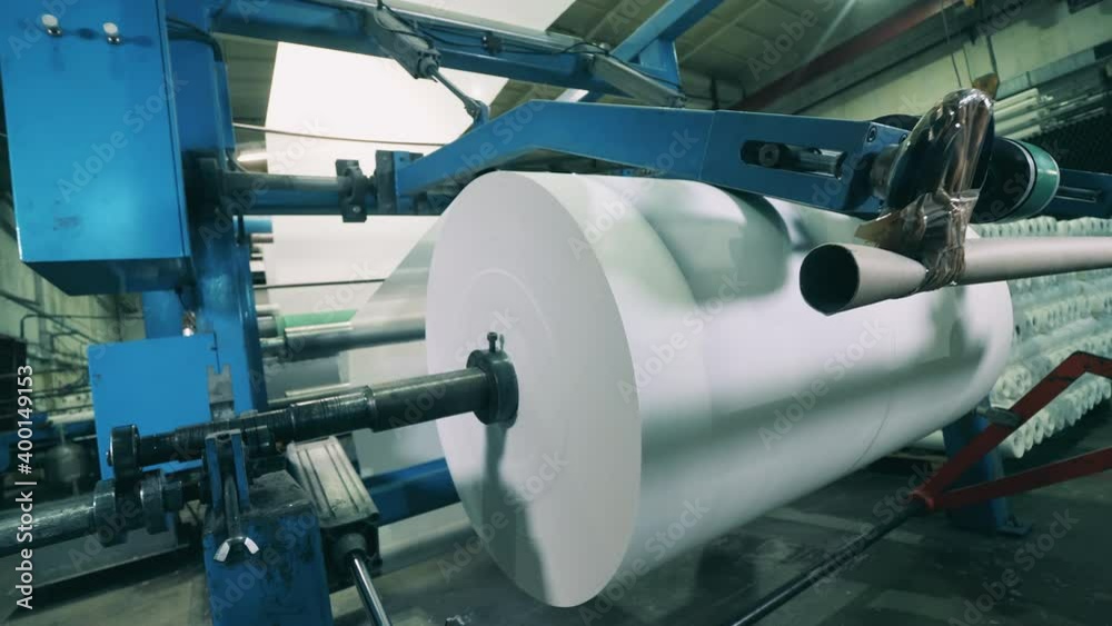 Factory machine with a massive paper roll getting wound