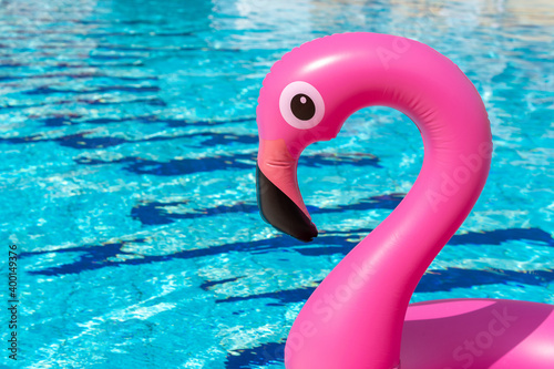 Summer sale. Pink inflatable flamingo in pool water for summer beach background. Minimal summer concept. © Maksym