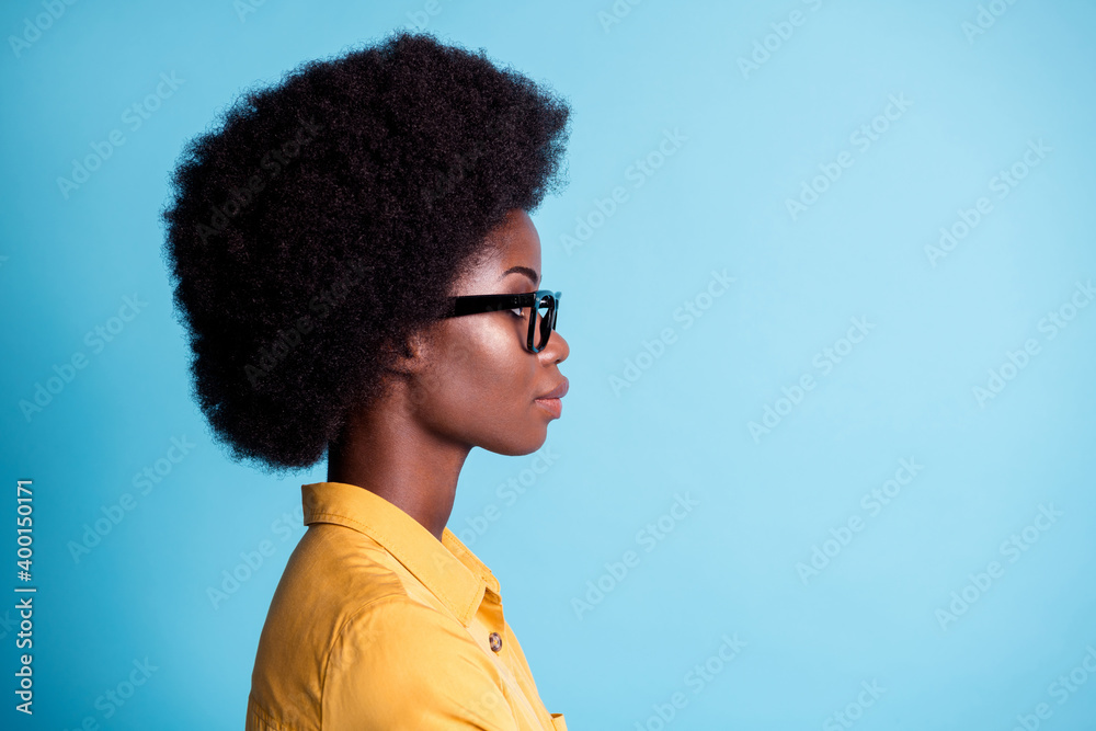 Closeup portrait side profile photo of dark skin big volume hairstyle lady  concentrated calm look empty space watch presentation wear specs yellow  shirt isolated blue color background Stock Photo | Adobe Stock
