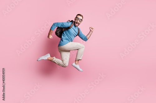 Full length photo of sweet funny man dressed blue sweater eyewear rucksack jumping parachute isolated pink color background