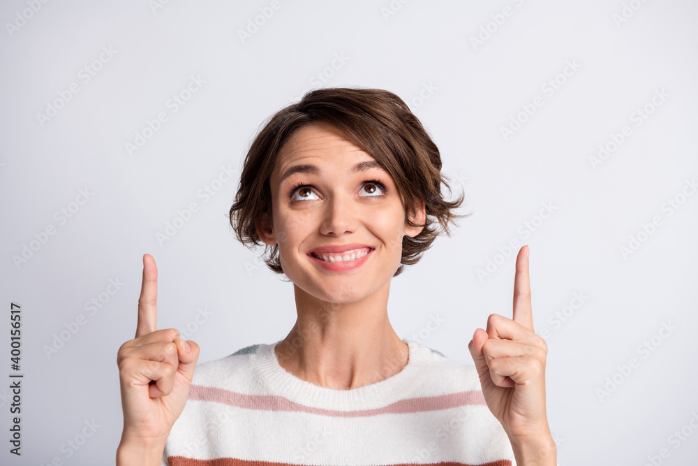 Close-up portrait of nice content cheerful brown-haired girl pointing forefinger up copy space look idea isolated over grey pastel color background Close-up portrait of nice content cheerful brown-haired girl pointing forefinger up copy space look idea isolated over grey pastel color background
