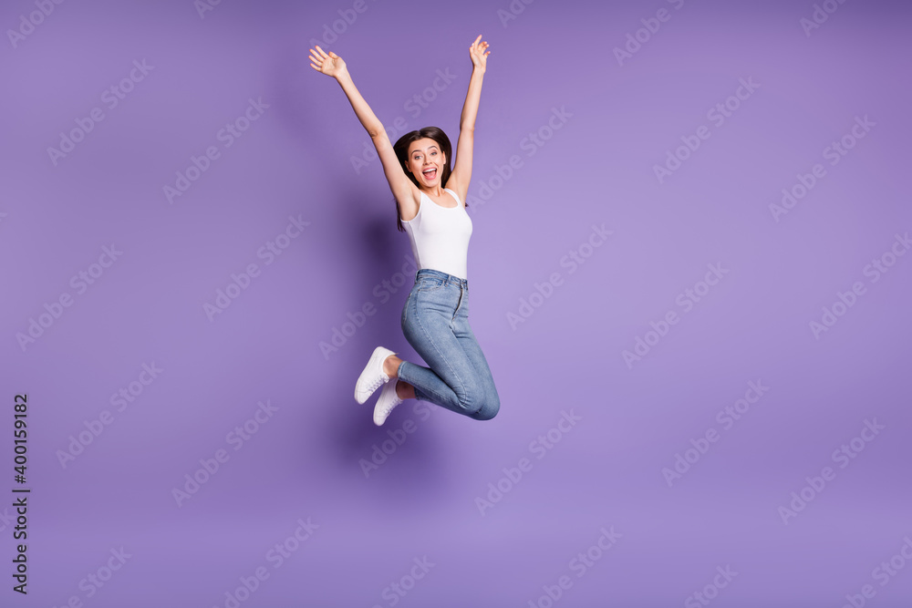 Full size photo of excited brown haired woman wear jeans jump up discount shopping isolated on violet color background