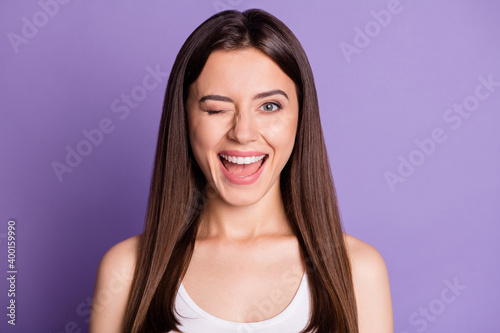 Photo portrait of winking girl isolated on vivid violet colored background
