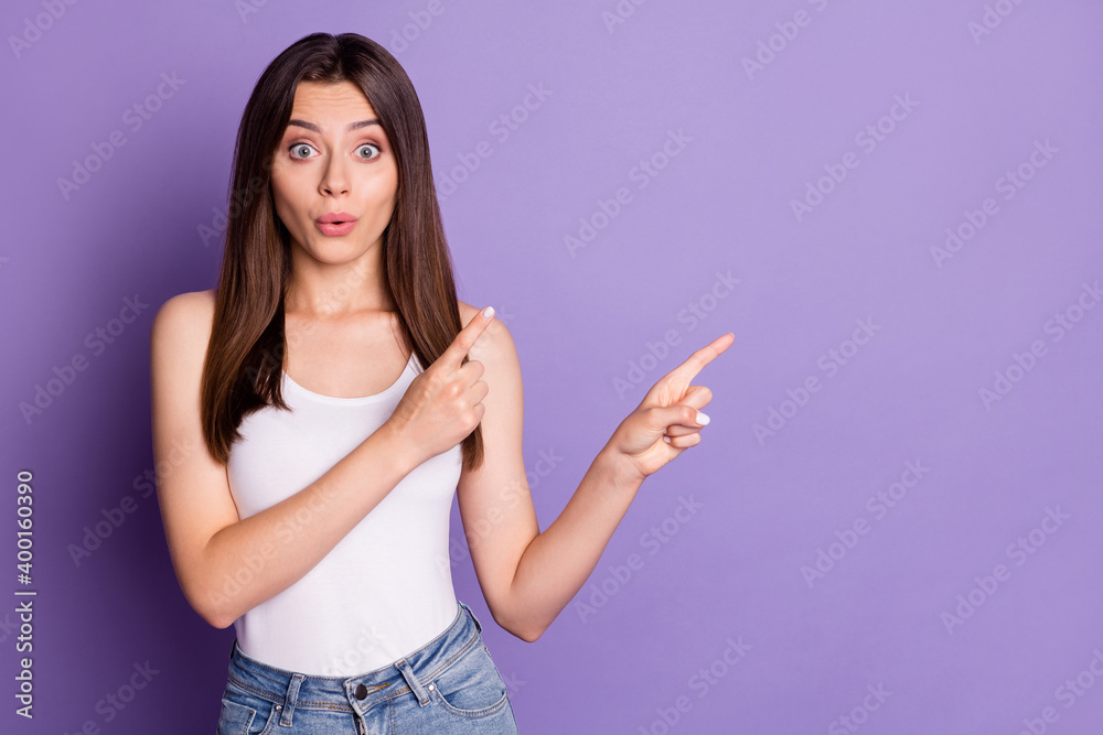 Photo of funny impressed young woman wear casual white outfit pointing two fingers empty space lips pouted isolated violet color background Photo of funny impressed young woman wear casual white outfit pointing two fingers empty space lips pouted isolated violet color background
