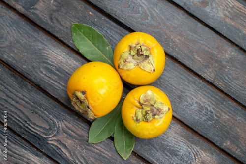 top view fresh sweet persimmons on wooden rustic desk fruit mellow tree photo