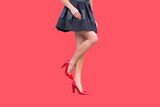 Kobiece nogi w szpilkach na kolorowym wyizolowanym tle, reklama moda i obuwie.