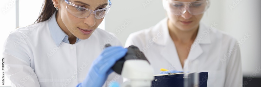 Two researchers in laboratory are doing research. Design research work in chemistry and medicine concept Two researchers in laboratory are doing research. Design research work in chemistry and medicine concept