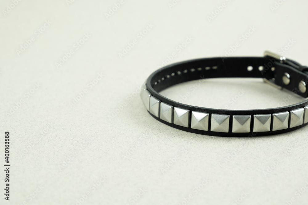 black leather bracelet close-up on a blurred gray background