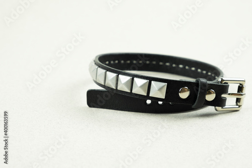 black leather bracelet Freddie Mercury with holniten close-up on a blurred gray background