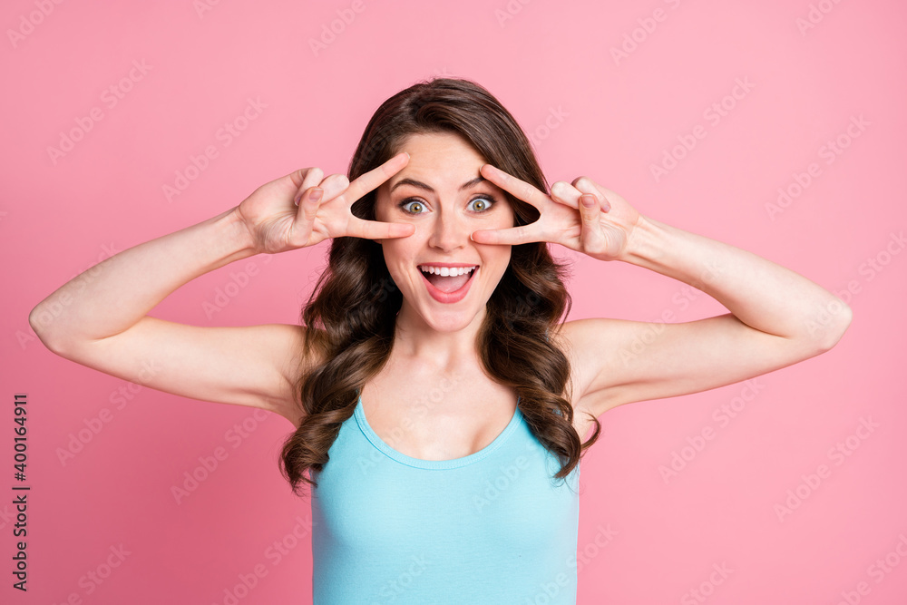 Close up photo of wavy person show v-sign near eyes open mouth impressed wear singlet isolated on pink color background Close up photo of wavy person show v-sign near eyes open mouth impressed wear singlet isolated on pink color background