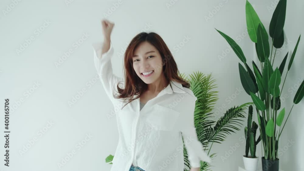 Beauty woman glad dancing with happy emotion and smiling in the white room Beauty woman glad dancing with happy emotion and smiling in the white room
