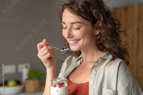 Photos Woman eating yogurt with berries at home