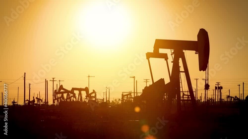 The sun rises behind oil pumps in California