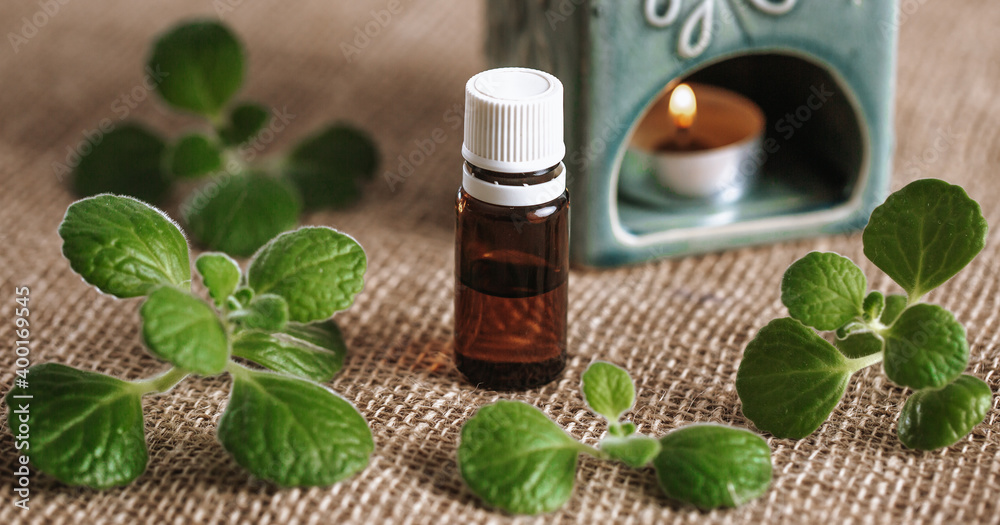 Close up of aroma lamp with burning candle and essential rhyme or plectranthus amboinicus oil, an aromatherapy concept Close up of aroma lamp with burning candle and essential rhyme or plectranthus amboinicus oil, an aromatherapy concept
