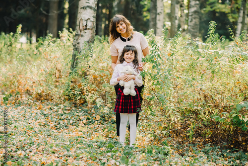 happy family of mom and daughter hugging and laughing in the fall