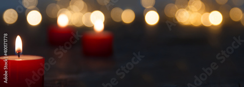 Christmas candle light with blurred golden bokeh for religious ritual and funeral service or spiritual meditation. Background for peaceful mind and soul with space for text.
