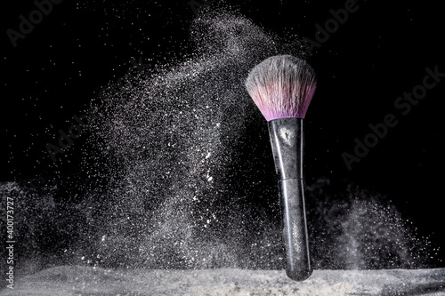 Pennello make up in movimento su sfondo scuro photo