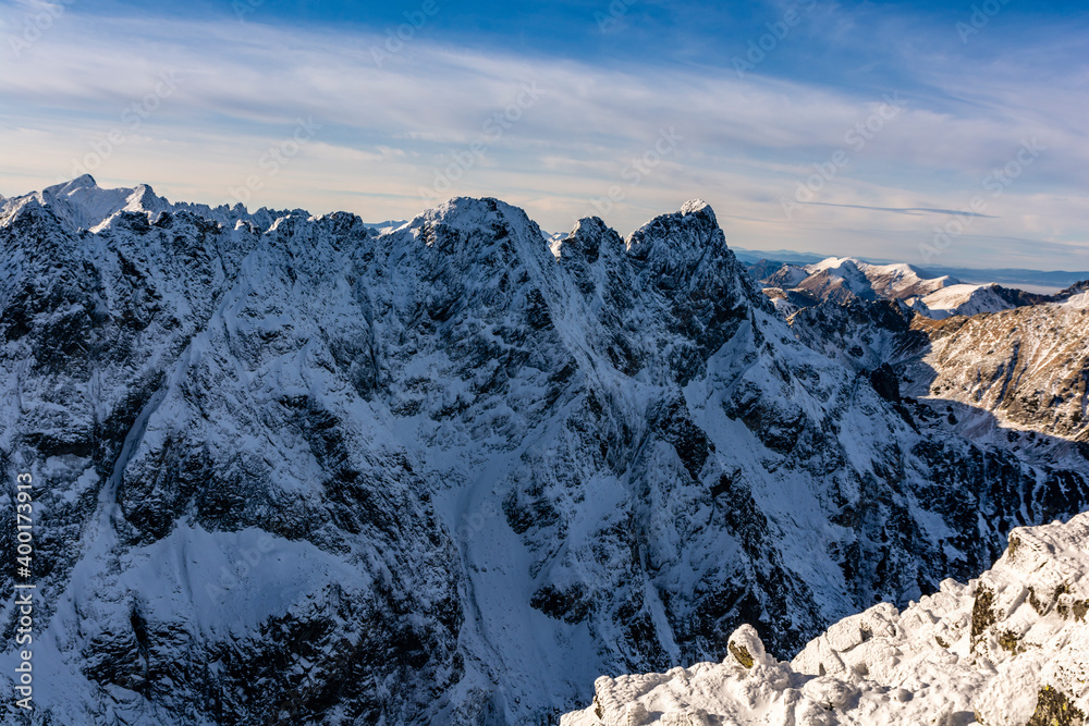 Obraz premium A fragment of the Main Ridge of the Tatra Mountains in the snow rime on a beautiful sunny and frosty day. Among the peaks, among others, Mieguszowiecki Summits.