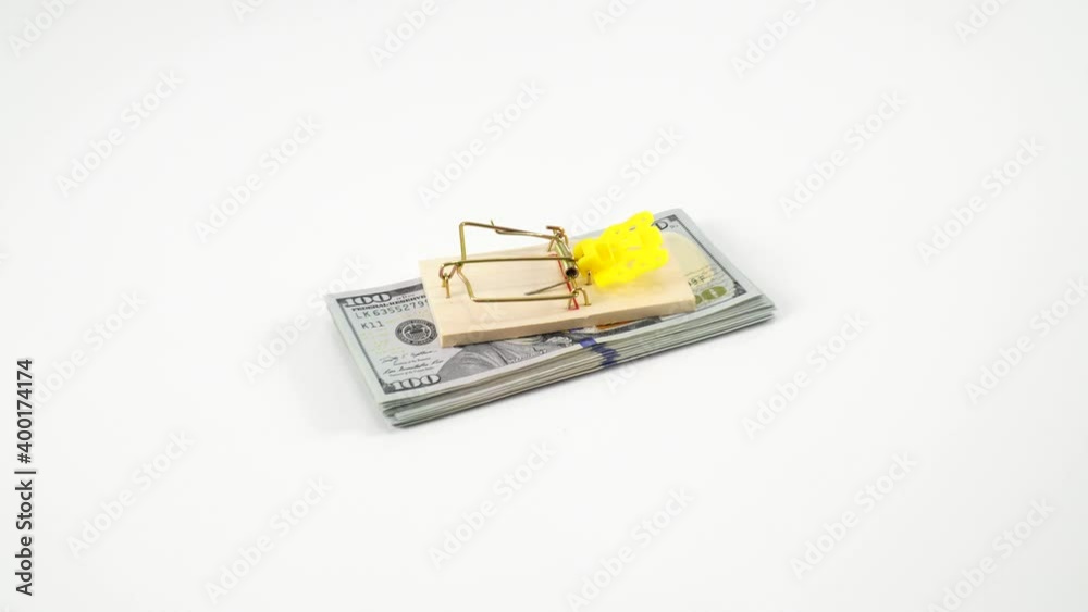 American dollars in a mousetrap. Money is like bait. Deception, fraud, bad loan and easy money concept. White studio background, blank mockup, place for text. Money is like bait.